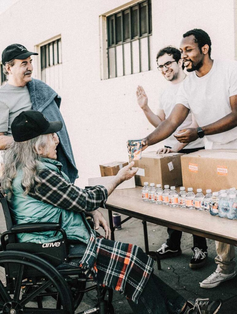Woman in wheelchair receiving food.